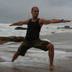 Image of Man Doing Warrior 2 Yoga Pose on a Beach