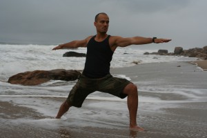 Image of Man Doing Warrior 2 Yoga Pose on a Beach